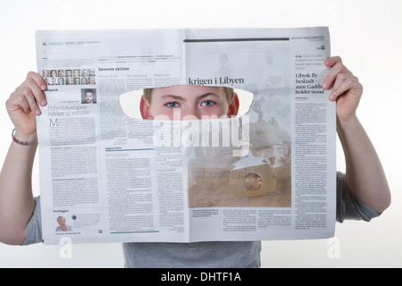 Boy looking through a newspaper hole as a spy Stock Photo