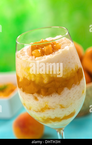 Fresh homemade rice pudding with peach compote served in a high glass Stock Photo