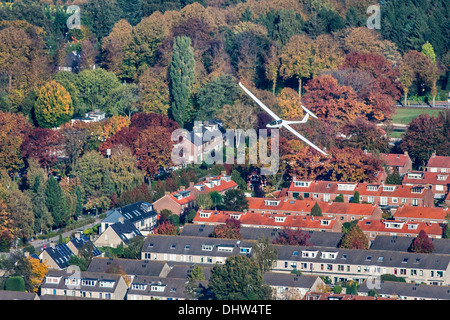 Netherlands, Loosdrecht, Glider or sailplane flying over village near airport. Aerial Stock Photo