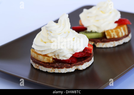 Puffed rice with fruits and cream on brown plate. Stock Photo