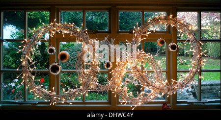 Christmas lights and baubles in the form of a wreath in window at The Bear Hotel Crickhowell, Powys, Wales UK  KATHY DEWITT Stock Photo