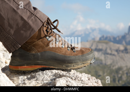 Hiking boots of a hiker on a rock in the mountains Stock Photo