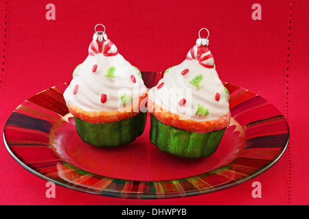 Two cupcake Christmas ornaments on a glass plate Stock Photo