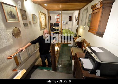Eisenach, Germany. 07th Nov, 2013. Klaus Trippstein, resident and owner of the 'Narrow House', poses in his house in Eisenach, Germany, 07 November 2013. With a width of 2.05 meters, it is probably the smallest inhabited half-timbered house in Germany. Klaus Trippstein's research has shown that the house is over 250 years old. Klaus Trippstein had bought the house in the mid-seventies and restored it piece by piece. The house hosts a small exhibition of paintings, sculptures and historic furnishings. Photo: Marc Tirl/dpa/Alamy Live News Stock Photo