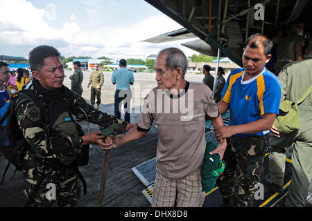 Armed Forces of the Philippines airmen aid an injured evacuee from Tacloban at Villamor Air Base November 14, 2013 in Manila, Philippines. Evacuees continue to be transported to Manila in the aftermath of super Typhoon Haiyan. Stock Photo