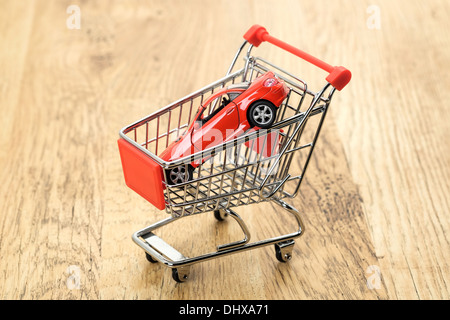 A conceptual image of an expensive sports car in a supermarket shopping cart Stock Photo