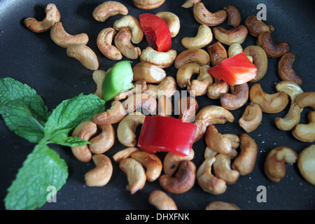 Focus Cashew nuts and bell pepper in pan. Stock Photo