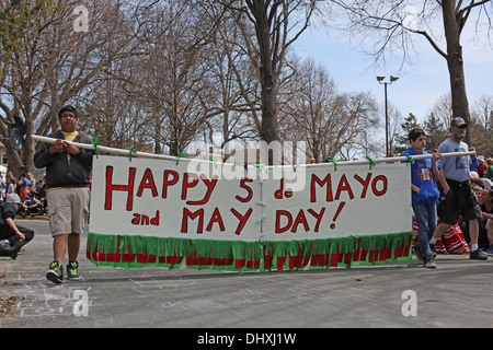 Marchers in the May Day parade in Minneapolis carrying a banner that reads happy May Day and Cinco de Mayo. Stock Photo