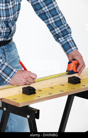 Carpenter measuring a plank Stock Photo
