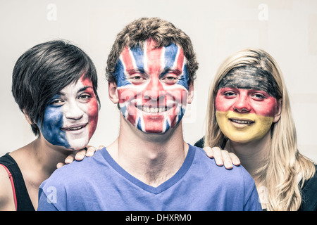 Portrait of happy young people with painted European flags on their faces. Stock Photo