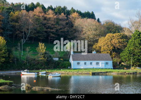 Moored boats and riverside home on the banks of the River Avon. Aveton Gifford, Devon. UK Stock Photo