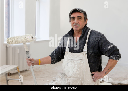 Painter and decorator working inside the renovation at Fairfield, Govan Glasgow, Scotland, UK Stock Photo