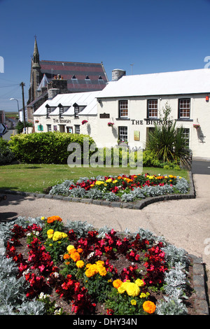 A row of cottages with a flower bed in the foreground. Stock Photo