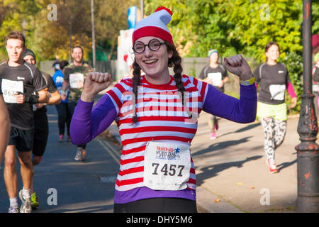 Battersea, London, UK. 16th November 2013. A 'Where's Wally?' competitor runs through Battersea Park at the Men's Health Survival of the Fittest 2013 event at Battersea Power Station. Credit:  Paul Davey/Alamy Live News Stock Photo
