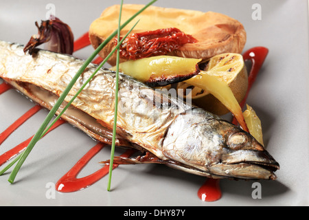 Roasted whole mackerel with potato and raspberry balsamic reduction Stock Photo