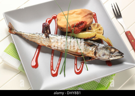 Roasted whole mackerel with potato and raspberry balsamic reduction Stock Photo