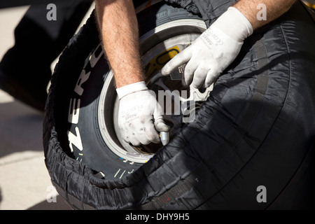 Mechanic checks temperature of tire during pit action at practice session for the Formula1 United States Grand Prix near Austin Stock Photo