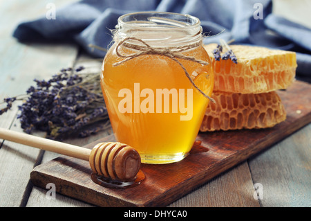 Honey in jar with honey dipper on vintage wooden background Stock Photo
