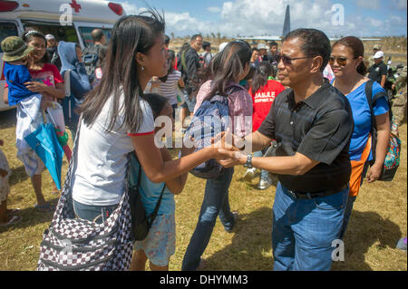 Philippine Vice President Jejomar Binay, right, shakes hands with residents waiting for humanitarian aid November 16, 2013 in Guiuan, Philippines. Stock Photo