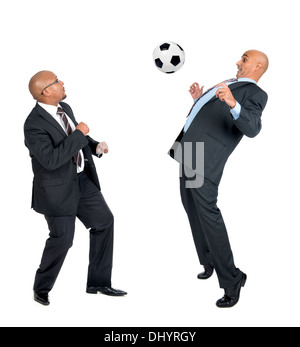 Businessmen playing soccer ball isolated in white Stock Photo