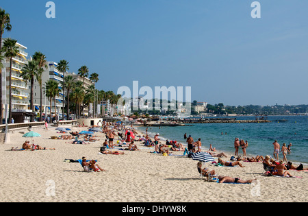 People sunbaking on Juan les Pins beach Cote d'Azure French Riviera Provence France Stock Photo