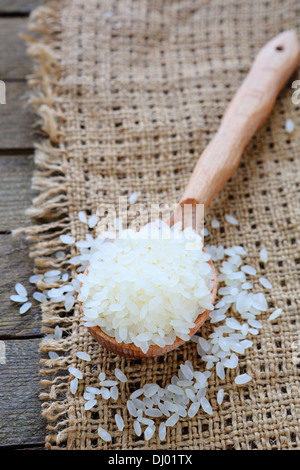 uncooked rice on wooden spoon, food close uo Stock Photo