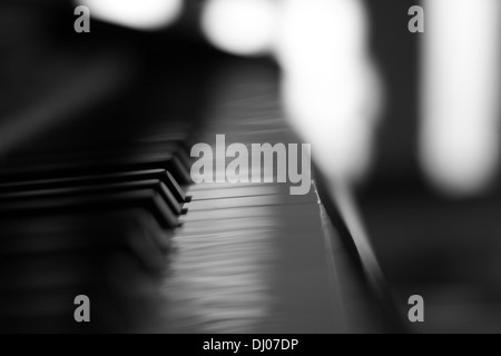 A piano with a shallow depth of field primarily focused on the middle key. Stock Photo