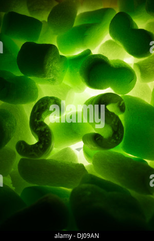 styrofoam packing peanuts glowing green Stock Photo