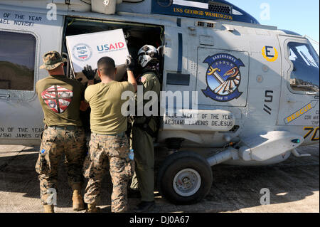 US Marines help load relief supplies onto an MH-60R Seahawk helicopter for distribution in the aftermath of Super Typhoon Haiyan November 17, 2013 in Guiuan, Philippines. Stock Photo