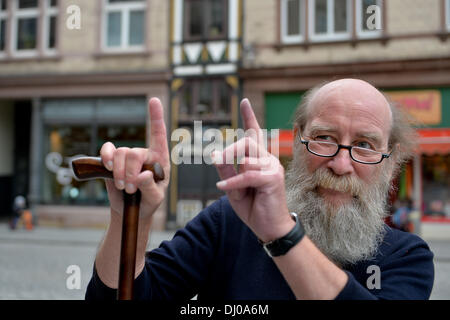 Eisenach, Germany. 07th Nov, 2013. Klaus Trippstein, resident and owner of the 'Narrow House', poses in front of his house in Eisenach, Germany, 07 November 2013. With a width of 2.05 meters, it is probably the smallest inhabited half-timbered house in Germany. Klaus Trippstein's research has shown that the house is over 250 years old. Klaus Trippstein had bought the house in the mid-seventies and restored it piece by piece. The house hosts a small exhibition of paintings, sculptures and historic furnishings. Photo: Marc Tirl/dpa/Alamy Live News Stock Photo