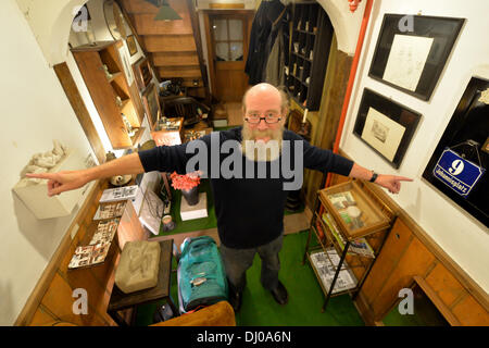 Eisenach, Germany. 07th Nov, 2013. Klaus Trippstein, resident and owner of the 'Narrow House', poses in his house in Eisenach, Germany, 07 November 2013. With a width of 2.05 meters, it is probably the smallest inhabited half-timbered house in Germany. Klaus Trippstein's research has shown that the house is over 250 years old. Klaus Trippstein had bought the house in the mid-seventies and restored it piece by piece. The house hosts a small exhibition of paintings, sculptures and historic furnishings. Photo: Marc Tirl/dpa/Alamy Live News Stock Photo