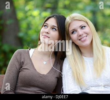 Two women enjoying nature while listening to music Stock Photo