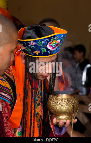 Bhutan, Thimpu Dzong, annual Tsechu, monk in embroidered costume lighting incense Stock Photo