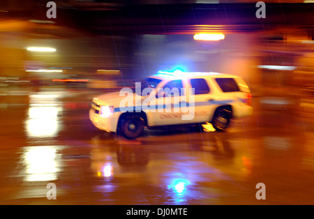 Chicago Police Chevrolet Chevy Tahoe (2006 - 2014) drives through heavy early morning rain blue lights flashing Stock Photo