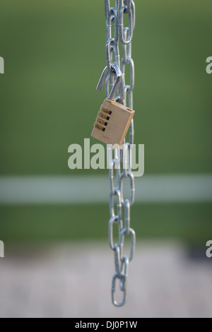Open padlock hanging from chain Stock Photo