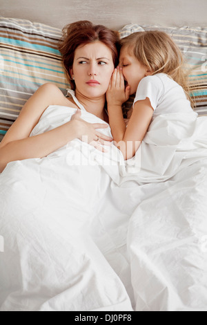 mother and daughter in bed,secret Stock Photo