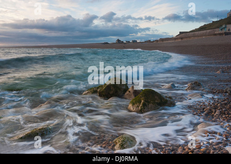 the sea at chesil beach in dorset looking toward the mainland taken at sunset with a long exposure Stock Photo