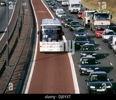 A coach passing a queue of morning rush hour traffic on the M4 bus lane near Heston, West London (prior to its closure in 2010). Stock Photo