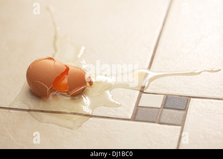 Fresh broken egg on the kitchen's floor Stock Photo