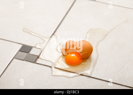 Fresh broken egg on the kitchen's floor Stock Photo