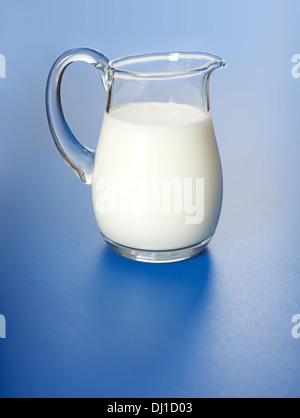 One liter milk in glass jug, on blue surface Stock Photo