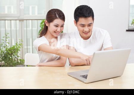 Young Couple Using Laptop at Home Stock Photo