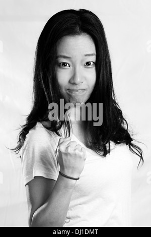 Portrait of attractive young woman clenching her fist for encouragement, black and white style Stock Photo