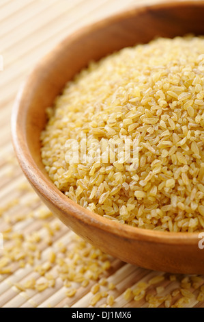 Wooden bowl full of bulgur wheat Stock Photo