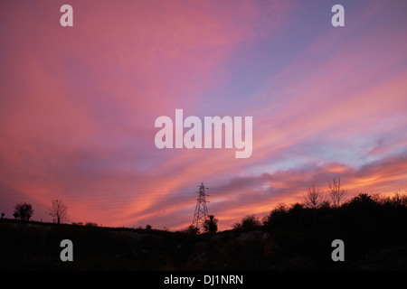 Red sunset behind an electricity pylon Stock Photo