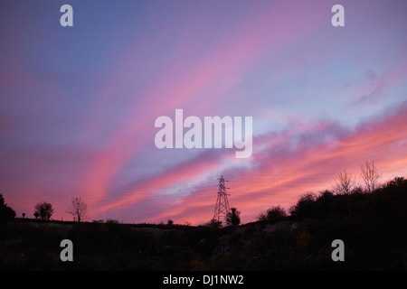 Red sunset behind an electricity pylon Stock Photo