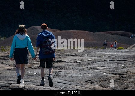 A couple making a trek over the lava of volcano Piton de la Fournaise. Reunion Island is formed by two volcanoes stratum mainly Stock Photo