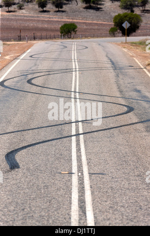Burn out car tyre marks on road from spiinning car wheels, Murchison Western Australia Stock Photo