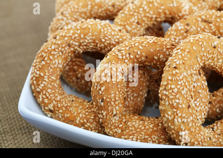 Round rusks with sesame seeds in white bowl. Stock Photo