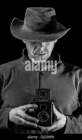 A man holding a vintage camera. Stock Photo